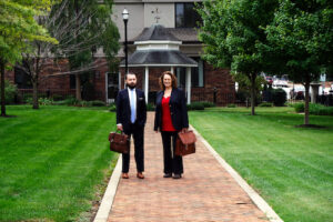 attorneys kent brown and flora templeton stuart carrying briefcases and standing on a sidewalk