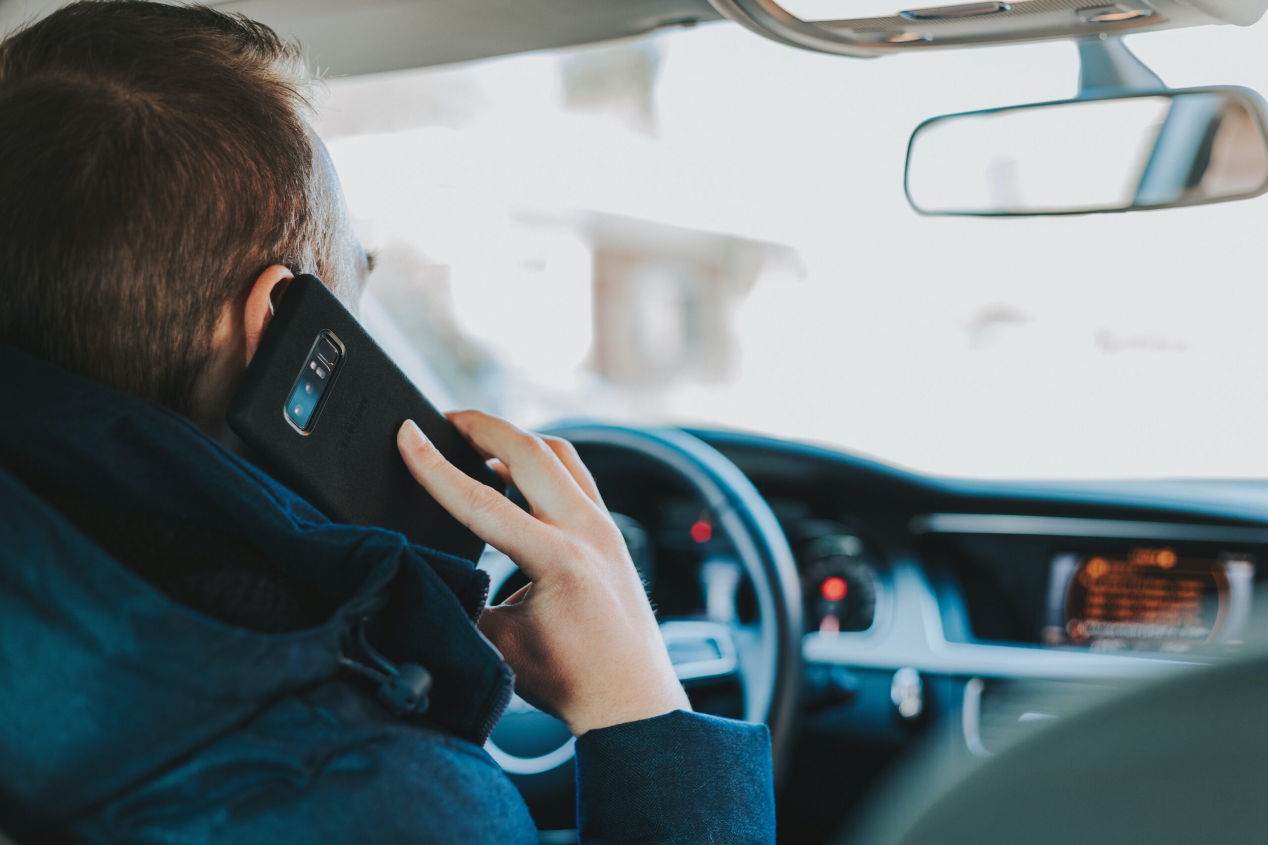 man driving while on phone