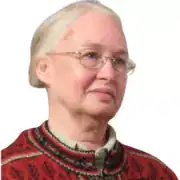 An older woman with light skin, glasses, and gray hair pulled back, wearing a red patterned sweater, faces slightly right against a white background—an image evoking the resilience of women in law who have challenged the glass ceiling.