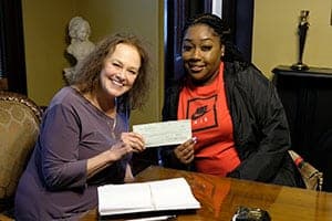 Flora Stuart delivering settlement check to client