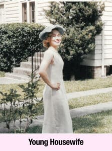 A young woman in a light dress and wide-brimmed hat stands smiling outdoors in front of a house and shrubbery, radiating the charm of a Southern Belle. Text at the bottom reads "Young Housewife.