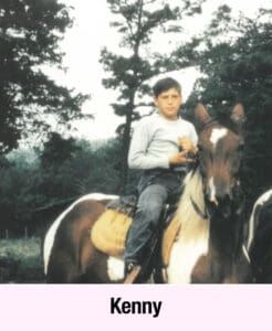 A boy wearing a long-sleeve shirt sits on a brown and white horse outdoors, with trees in the background. The name "Kenny" appears in bold text at the bottom, capturing a moment of empowerment and quiet confidence.