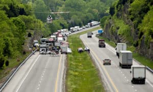 A helicopter lands near emergency vehicles responding to an accident on a busy Bowling Green highway, with traffic backed up in one direction—an all-too-common scene in wrongful death cases.