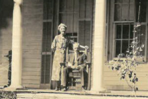 An elderly woman stands beside an elderly man seated in a rocking chair on a porch, with columns and a plant visible. Text reads, "Papa and Big Mama." Their journey spans generations, from Scotland to Louisiana.
