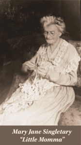 Elderly woman with glasses and gray hair sits on a patterned chair, crocheting with white yarn. Text at bottom reads: "Mary Jane Singletary 'Little Momma'," honoring her slave ancestry.